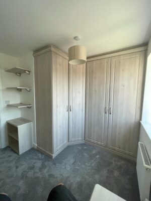 fitted wardrobes in small corner with matching shelves and drawers storage
